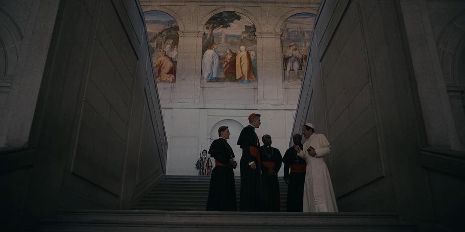 Pope Duretti talks to his Cardnials about the threat of Adriel as he walks down the stairs.