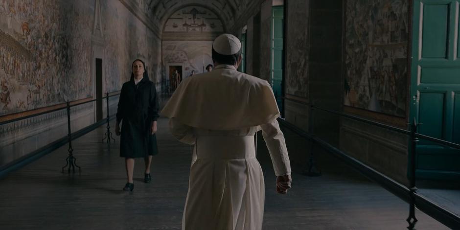 Pope Duretti passes a nun in the hallway.