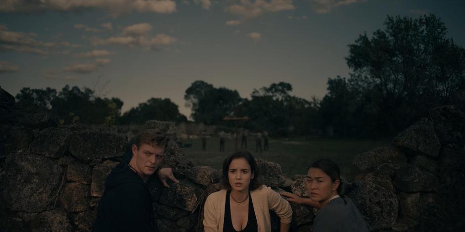 Miguel, Ava, and Bea turn to see the locusts arriving.