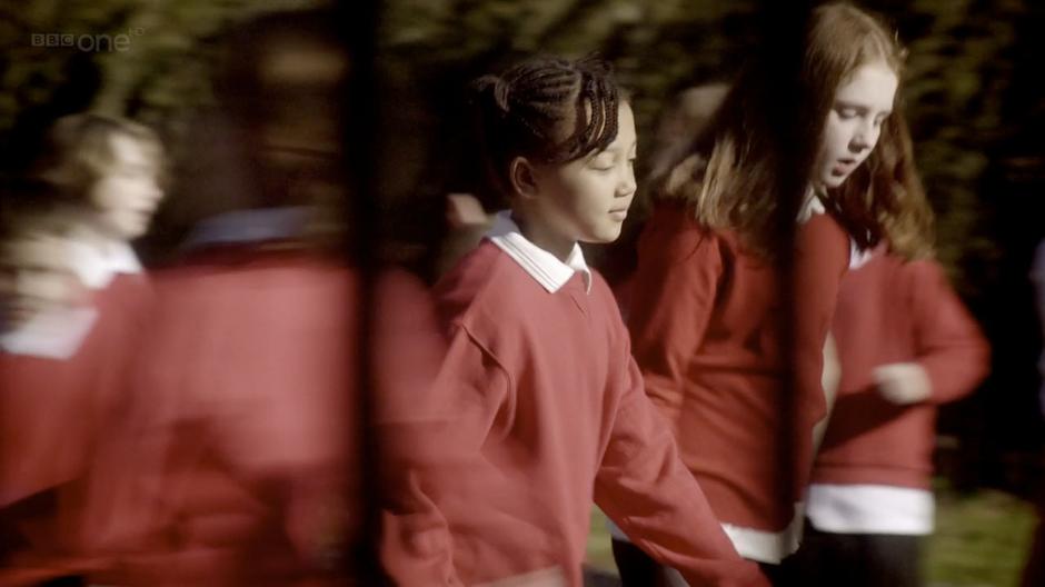 Amelia and Mels walk through the schoolyard.