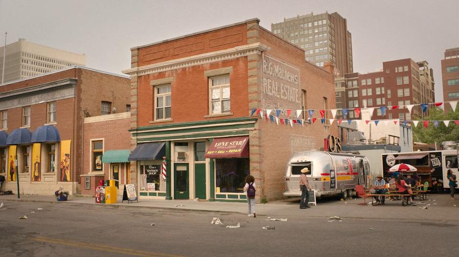 Sarah crosses the street towards the jewelry store.