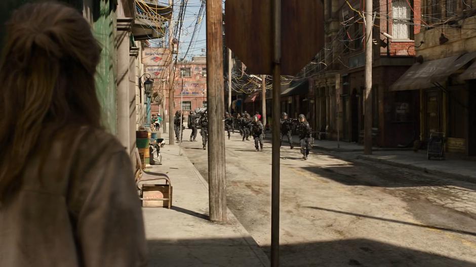 Tess turns the corner to see a bunch of FEDRA soldiers rushing down the street.