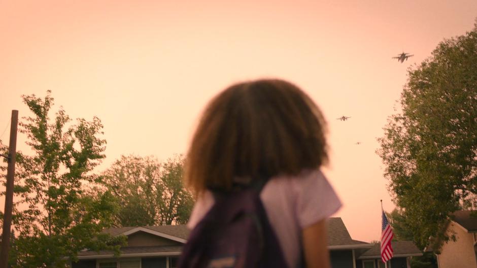 Sarah watches several fighter jets fly overhead.