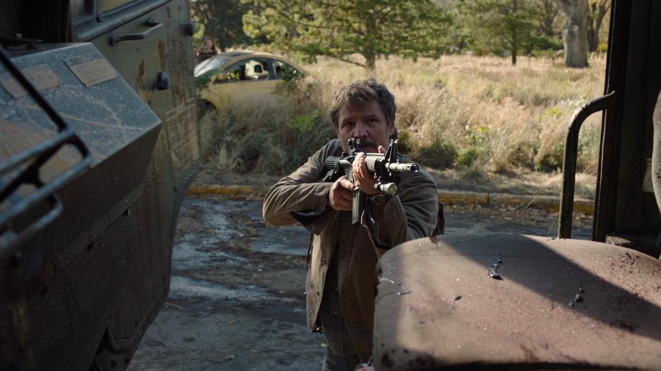 Joel holds up his gun as he opens the cab of the truck.