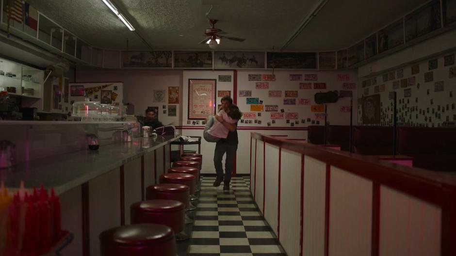 Joel races through the diner with Sarah as the infected chases them.