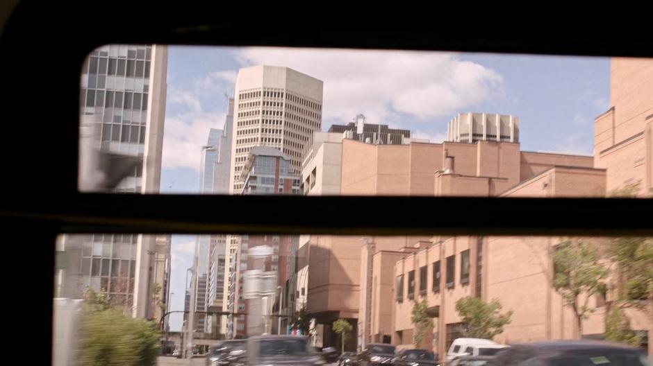 The talls buildings of downtown Austin are visible out of the bus window.