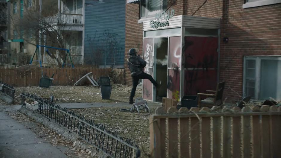 Someone kicks down the door to an apartment building.