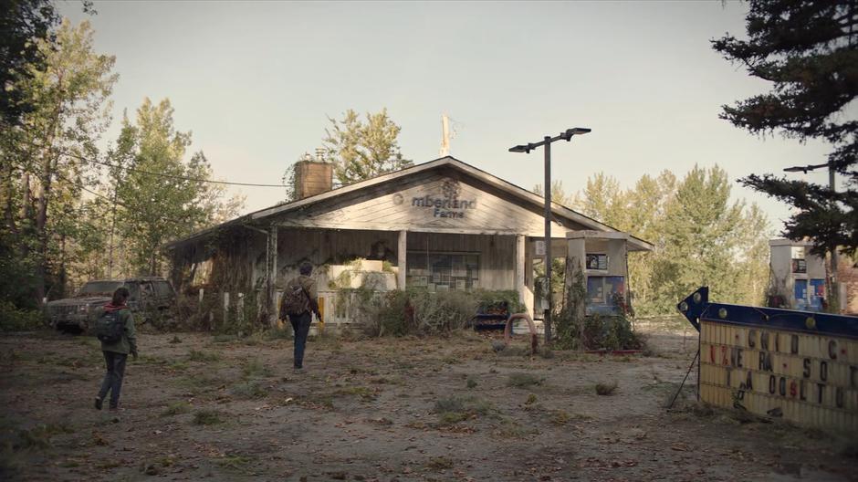 Ellie follows Joel towards the overgrown country store.