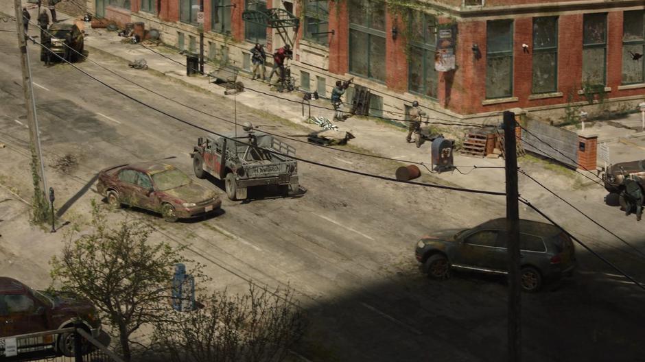 A revolutionary patrol drives between stopped cars on the street while others search for the fugitives.