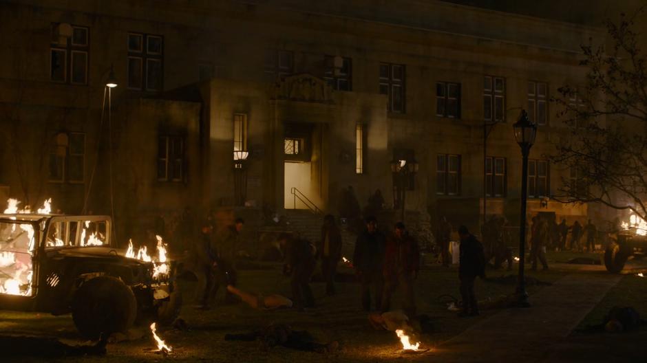 The revolutionaries attack former FEDRA officers and collaborators in a square next to a burning humvee.