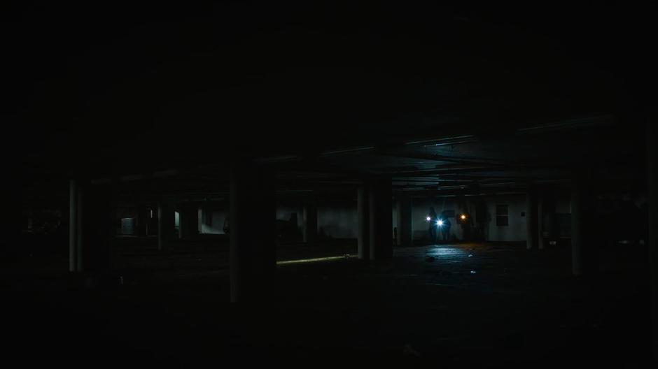 Joel, Ellie, Henry, and Sam emerge from the tunnel into a parking garage.