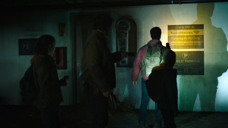 Ellie, Joel, Henry, and Sam examine the sign that indicates they made it across the highway.