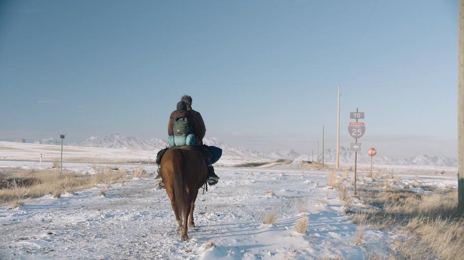 Ellie and Joel approach the intersection with a sign pointing towards I-25.