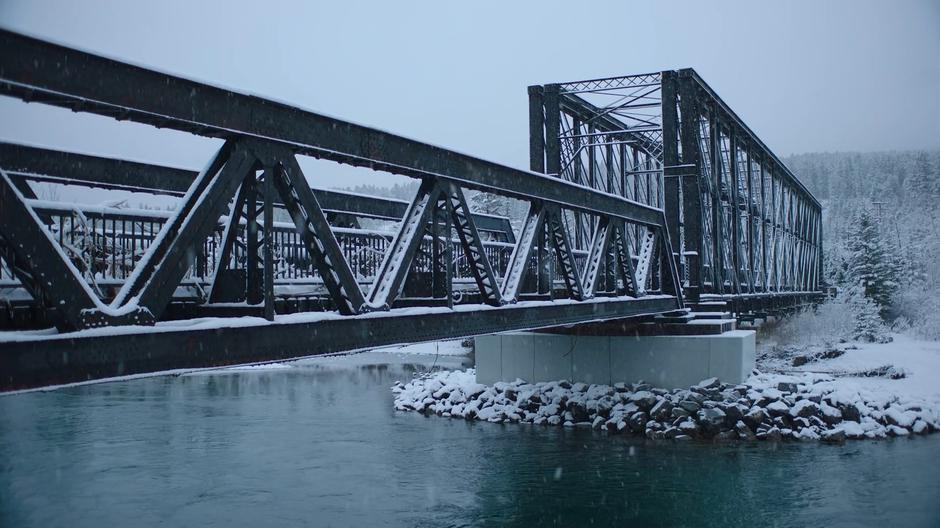 Snow falls around the bridge.