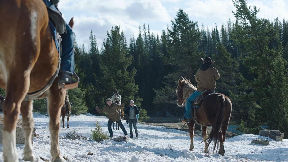 Joel stands after placing his rifle on the ground at the insistence of the riders.