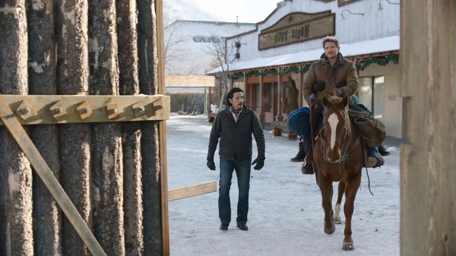 Tommy escorts Joel and Ellie through the gate out of town.