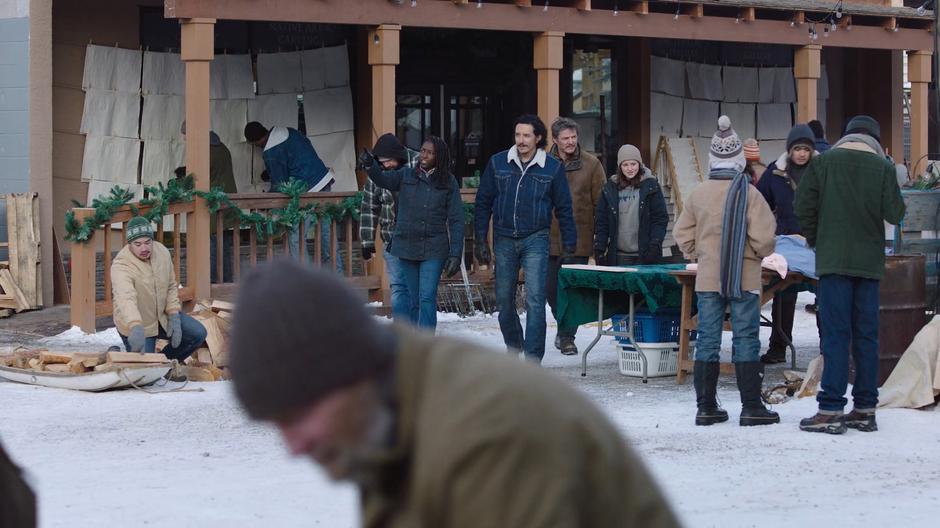 Maria points things out as she and Tommy take Joel and Ellie on a tour of the town.