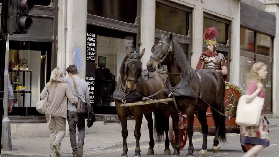 A charioteer waits at the corner for the light to change.