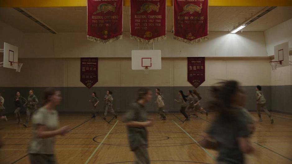 Ellie runs in a circle listening to her Walkman with the other students.