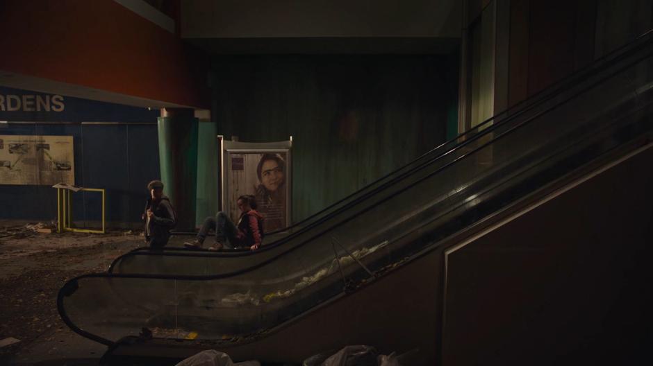 Riley looks back at Ellie as she plays on the escalator.