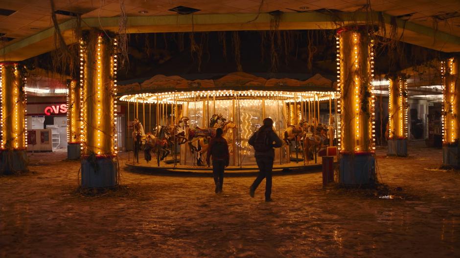 Ellie approaches the carousel as Riley heads to the controls.