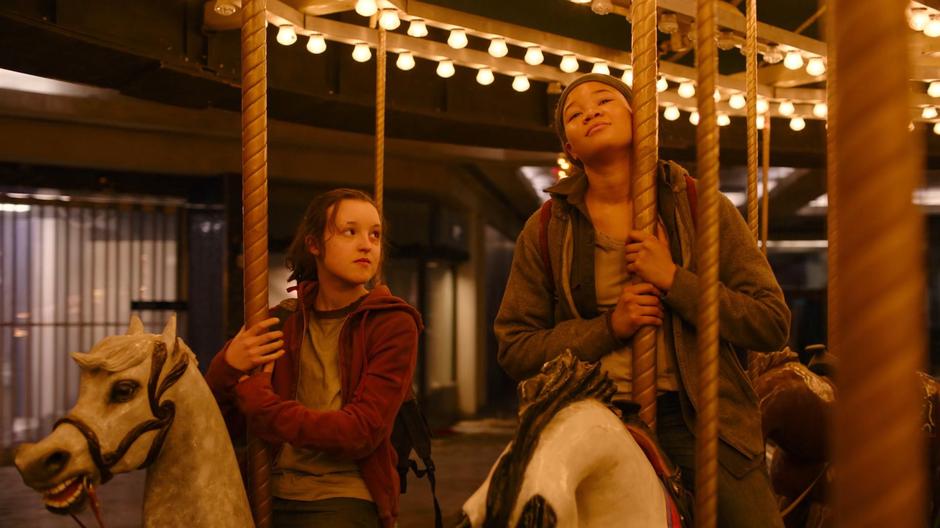 Ellie stares up at Riley as they ride the carousel.