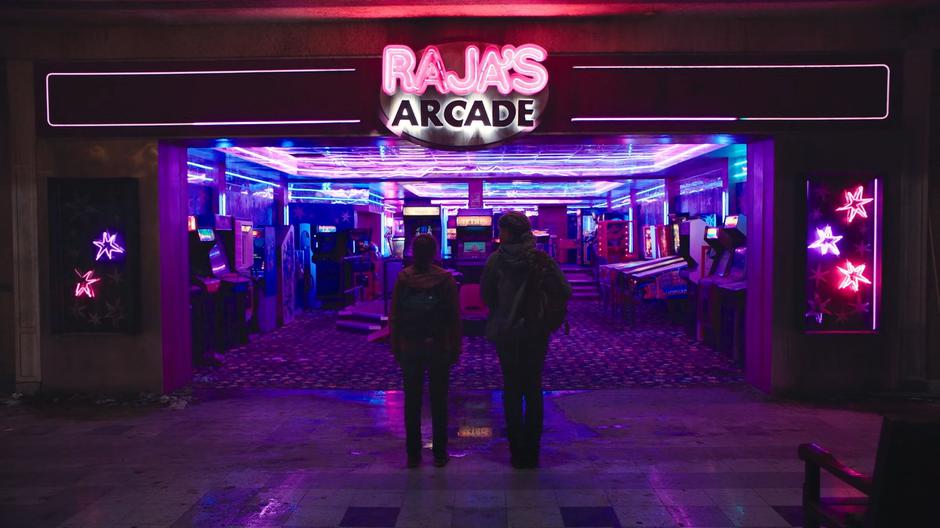 Riley looks at Ellie as she stands in awe at the entrance of the arcade.