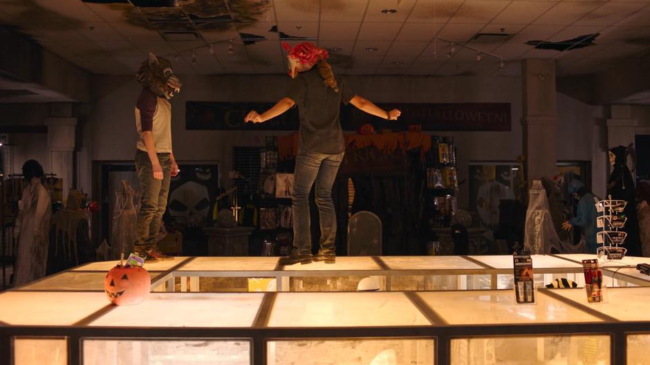 Ellie and Riley dance on the top of the glass counter in the halloween store.