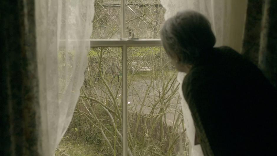 An old woman looks out at the group.