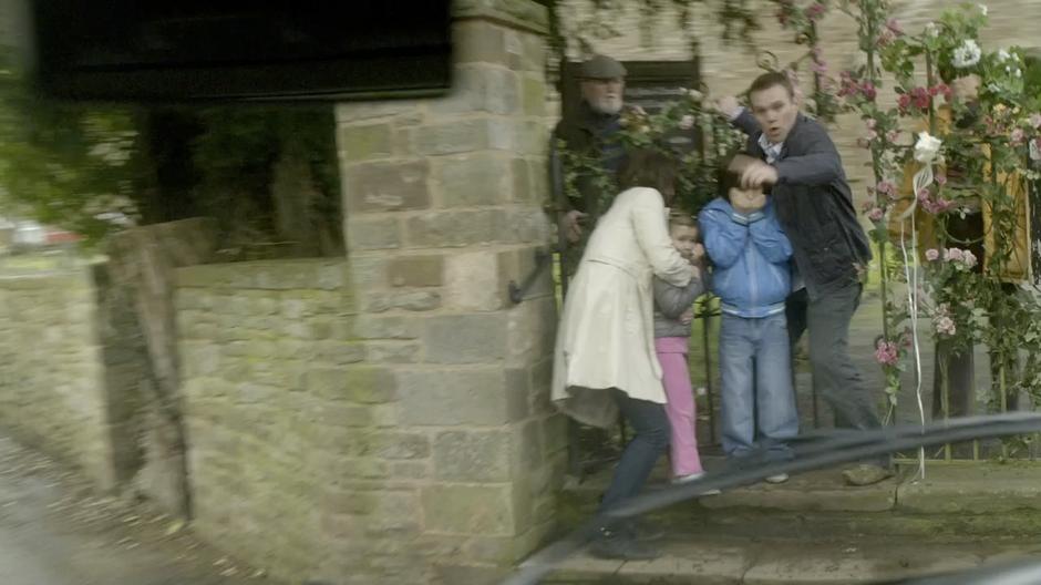 The Doctor rescues a family from in front of the church gate.