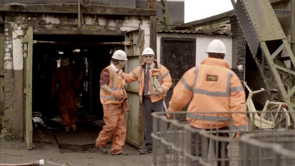 The previous shift of workers exit the dig site.