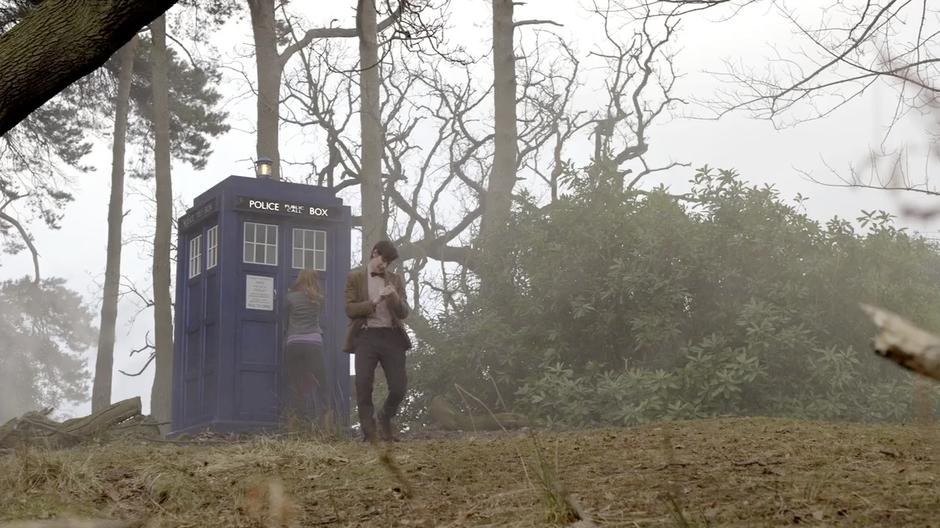 The Doctor walks towards the camp while Amy closes the door of the TARDIS.