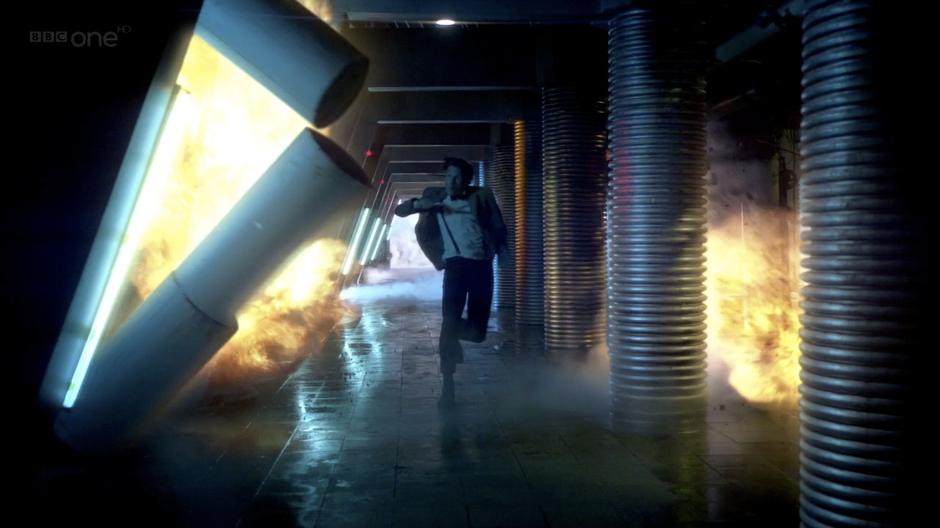 The Doctor runs through a spacecraft as it explodes around him.