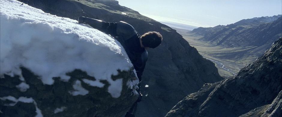 Bruce tries to stop Henri Ducard from falling off a cliff.