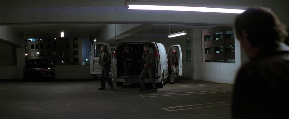 Scarecrow's men exit their van.