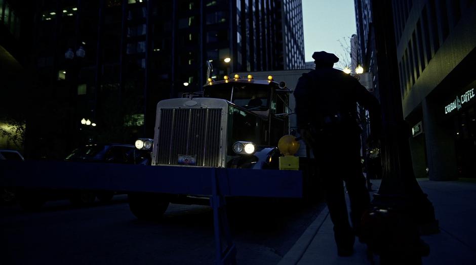 A police officer walks up to the semi-truck carrying the Joker.