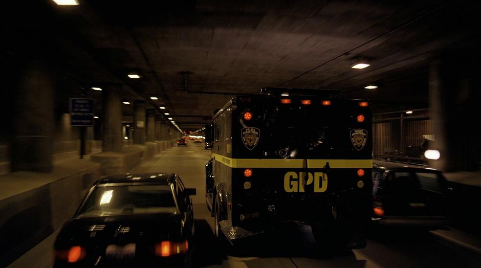 The armored car carrying Harvey Dent attempts to escape the Joker's semi-truck.