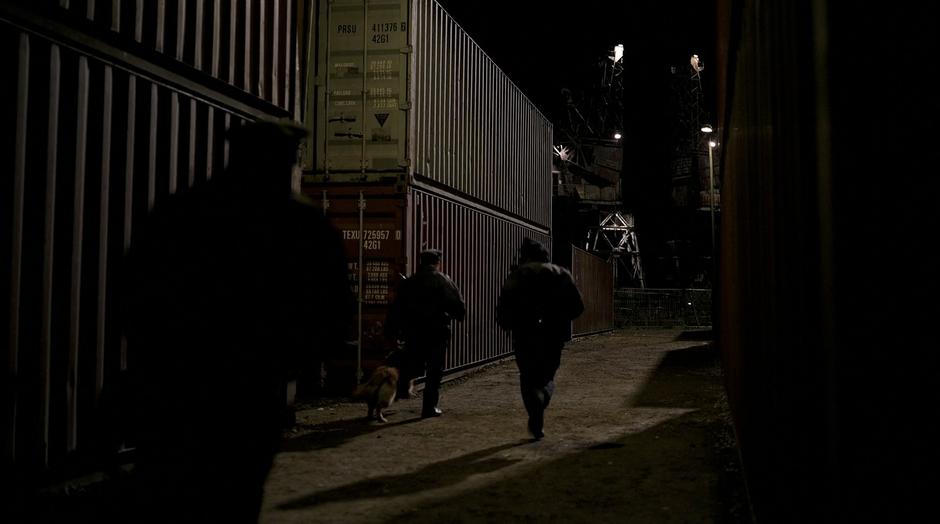 The police search for Batman amongst the containers.