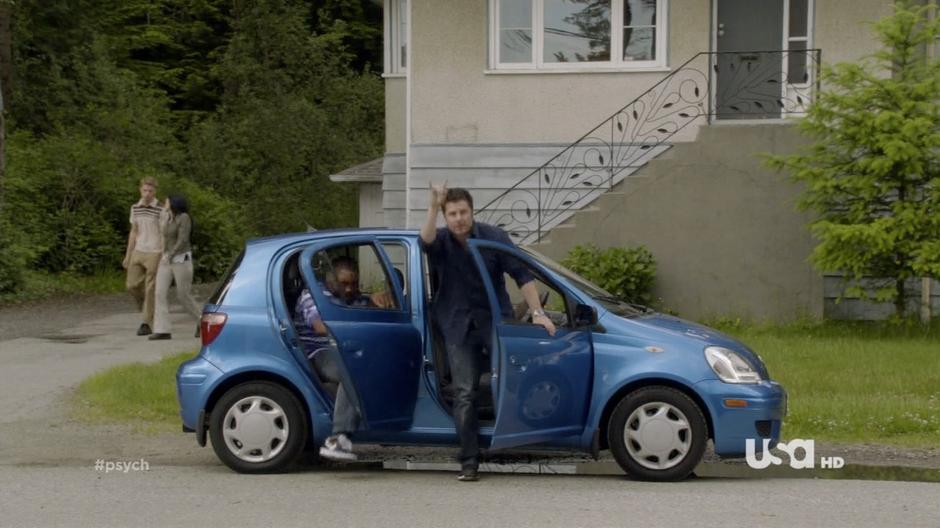 Shawn greets Juliet while Gus gets out of the Blueberry across from he construction company.