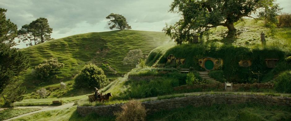 Gandalf rides his cart up to Bag End to meet with Bilbo.