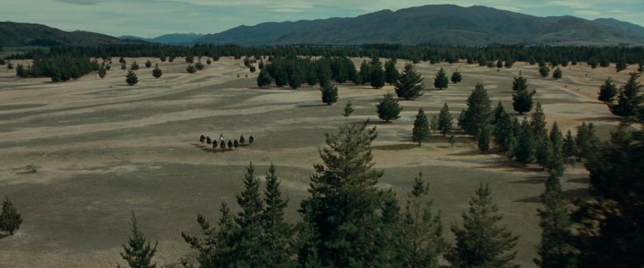 The Black Riders pursue Arwen and Frodo through an open field.