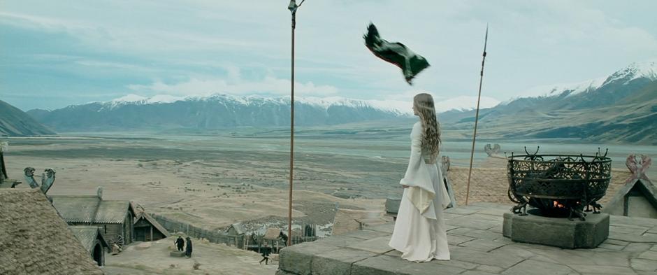 Eowyn looks out over the valley as the flag of Rohan blows away in the wind.