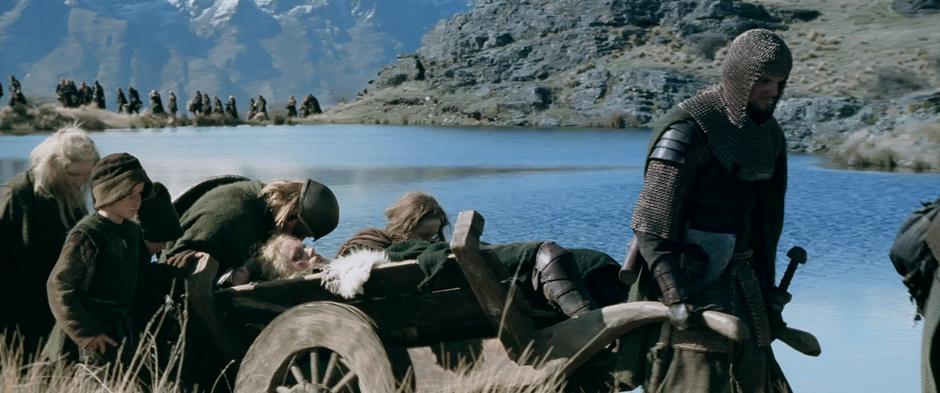 Refugees from Edoras trek around a lake in Rohan.
