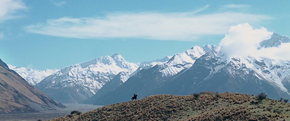 Aragorn comes to the top of a hill and looks over at Helm's Deep.