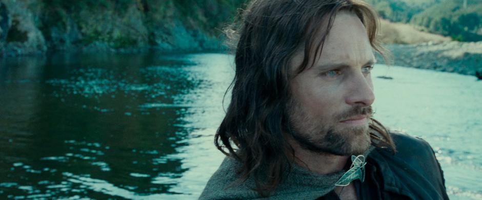 Aragorn watches the shore while he paddles down the river.
