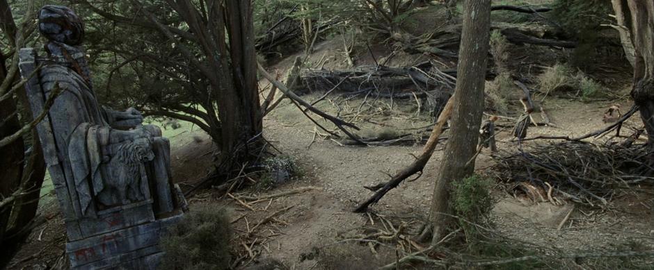 Sam, Frodo, and Gollum walk away from the vandalized statue.