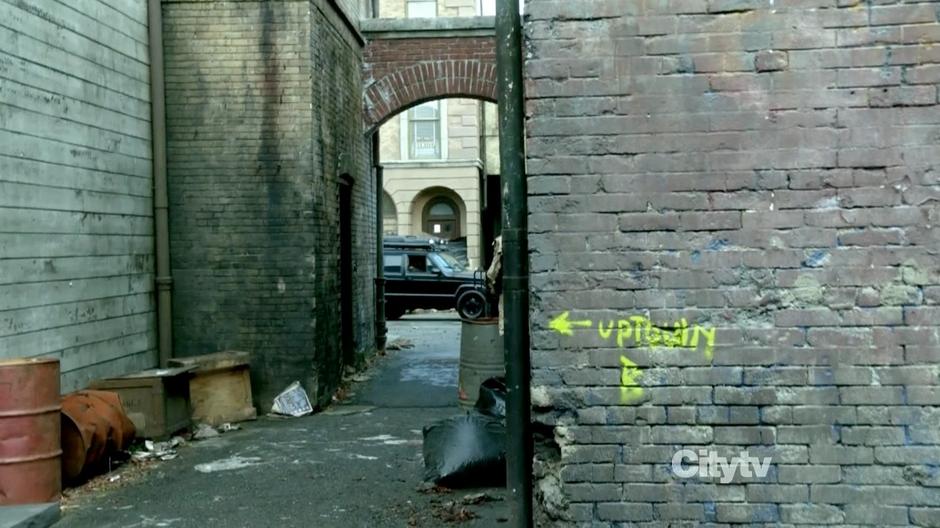 A police vehicle pulls up outside the alley.