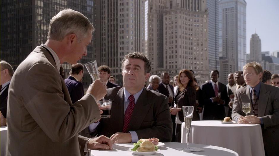 Victor Dubenich talks with his lawyer at the shareholder party in the plaza next to his office building.