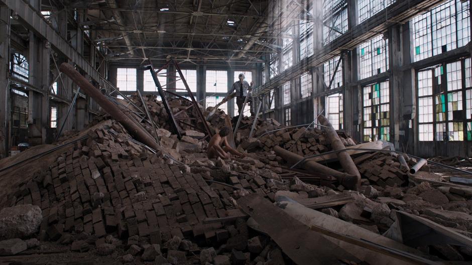 A naked Bruce Banner wakes up in a pile of debris while a security guard looks on.