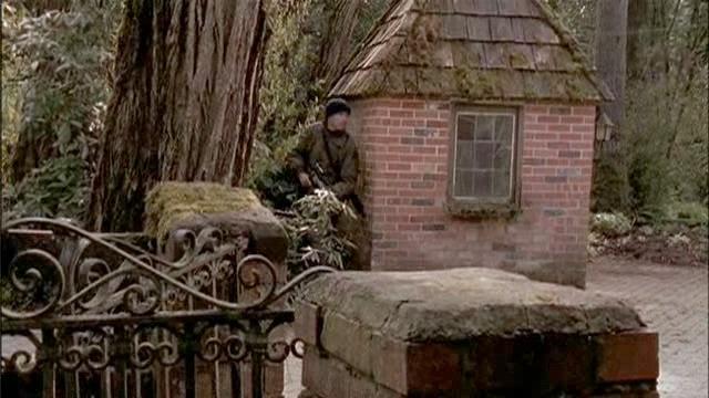 Charles Kawalsky takes cover by a small structure on the road leading to the main building.